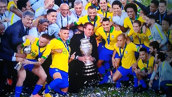 Imagem 1 -  Seleção Brasileira possa com o troféu com o presidente Jair Bolsonaro