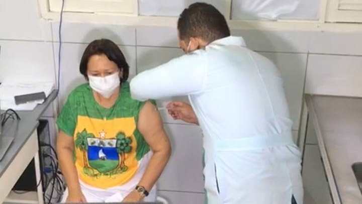   Fátima Bezerra recebe primeira dose da vacina contra a Covid-19 em Natal. A governadora do Rio Grande do Norte foi vacinada por volta das 12h30, na Unidade Básica de Saúde do bairro Candelária. Fátima tem 65 anos e está dentro da faixa etária que está sendo imunizada no município de Natal. Durante a aplicação da vacina, que foi acompanhada pelo secretário de saúde, Cipriano Maia, a governadora agradeceu aos profissionais e reafirmou o compromisso de continuar trabalhando para combater o vírus no estado.