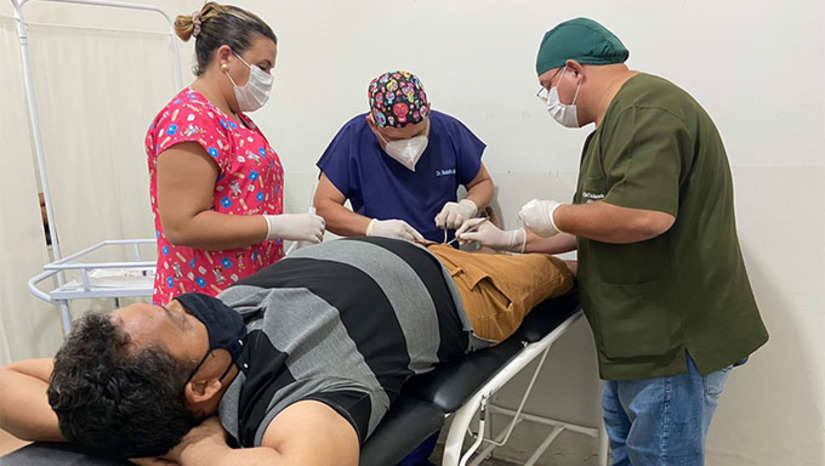 Imagem 1 - Os procedimentos cirúrgicos, que não precisam de grandes estruturas e menos ainda de suporte de UTI, estão sendo realizados na Unidade Básica de Saúde João Marinaldo de Holanda (PSF 1), tendo à frente o médico Rodolfo Maciel, auxiliado pela técnica de enfermagem Bruna Raphaela. No total, o médico atendeu 25 pessoas e retirou 76 lesões Imagem 1 - Os procedimentos cirúrgicos, que não precisam de grandes estruturas e menos ainda de suporte de UTI, estão sendo realizados na Unidade Básica de Saúde João Marinaldo de Holanda (PSF 1), tendo à frente o médico Rodolfo Maciel, auxiliado pela técnica de enfermagem Bruna Raphaela. No total, o médico atendeu 25 pessoas e retirou 76 lesões