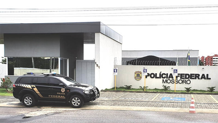 Imagem 1 - Motorista de aplicativo é investigado por se passar por delegado da PF em Mossoró. Os policiais estão cumprindo um mandado de busca e apreensão expedido pela 10ª Vara da Justiça Federal/RN, em um endereço residencial no bairro Aeroporto. O investigado, um homem de 29 anos, responde a dois processos pela prática de crimes previstos no Estatuto do Desarmamento. A investigação teve início no mês de maio deste ano quando uma mulher procurou a Delegacia da PF em Mossoró para relatar que estaria sendo assediada por uma pessoa que teria se identificado como delegado da PF e que teria enviado credenciais de membro da instituição, após suposta interação ocorrida em um aplicativo de relacionamento. Imagem 1 - Motorista de aplicativo é investigado por se passar por delegado da PF em Mossoró. Os policiais estão cumprindo um mandado de busca e apreensão expedido pela 10ª Vara da Justiça Federal/RN, em um endereço residencial no bairro Aeroporto. O investigado, um homem de 29 anos, responde a dois processos pela prática de crimes previstos no Estatuto do Desarmamento. A investigação teve início no mês de maio deste ano quando uma mulher procurou a Delegacia da PF em Mossoró para relatar que estaria sendo assediada por uma pessoa que teria se identificado como delegado da PF e que teria enviado credenciais de membro da instituição, após suposta interação ocorrida em um aplicativo de relacionamento.
