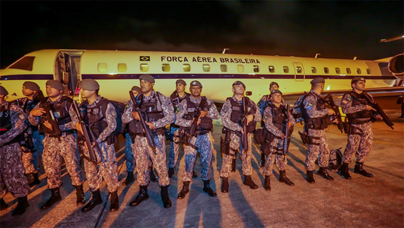 Imagem 1 - 100 policiais da Força Nacional desembarcaram nesta quarta-feira (15), no RN. Os agentes foram disponibilizados pelo Ministério da Justiça e Segurança Pública (MJSP), a pedido da governadora Fátima Bezerra, para dar apoio às ações de combate à criminalidade no Estado. O grupo é parte de um total de mais 200 agentes de segurança que virão ao RN. Além dos que já estão em solo potiguar, cerca de 100 agentes vêm para Natal nesta manhã, em 30 viaturas que também irão atuar no Estado. Até esta madrugada, 25 pessoas suspeitas de envolvimento nas ações criminosas foram presas pela Polícia Militar. Armas, drogas, artefatos explosivos, veículos, dinheiro e munições foram apreendidos. Imagem 1 - 100 policiais da Força Nacional desembarcaram nesta quarta-feira (15), no RN. Os agentes foram disponibilizados pelo Ministério da Justiça e Segurança Pública (MJSP), a pedido da governadora Fátima Bezerra, para dar apoio às ações de combate à criminalidade no Estado. O grupo é parte de um total de mais 200 agentes de segurança que virão ao RN. Além dos que já estão em solo potiguar, cerca de 100 agentes vêm para Natal nesta manhã, em 30 viaturas que também irão atuar no Estado. Até esta madrugada, 25 pessoas suspeitas de envolvimento nas ações criminosas foram presas pela Polícia Militar. Armas, drogas, artefatos explosivos, veículos, dinheiro e munições foram apreendidos.