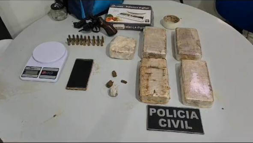 Imagem 1 - Mulher é presa com cerca de 5kg de crack e uma arma de fogo, na Nova Mossoró. A prisão aconteceu nesta terça-feira (26). Durante as diligências decorrentes de uma investigação sobre o roubo de um aparelho celular, a polícia conseguiu localizar a residência onde o suspeito estava. Ao perceber a presença dos policiais, ele empreendeu fuga e pulou os muros de residências próximas, abandonando uma mochila que continha um revólver calibre 38, 18 munições do mesmo calibre, cerca de cinco quilos de crack, porções de maconha, uma balança de precisão e dois aparelhos celulares. Após recuperarem a mochila, os agentes retornaram à residência de origem e prenderam uma mulher que estava no local. Imagem 1 - Mulher é presa com cerca de 5kg de crack e uma arma de fogo, na Nova Mossoró. A prisão aconteceu nesta terça-feira (26). Durante as diligências decorrentes de uma investigação sobre o roubo de um aparelho celular, a polícia conseguiu localizar a residência onde o suspeito estava. Ao perceber a presença dos policiais, ele empreendeu fuga e pulou os muros de residências próximas, abandonando uma mochila que continha um revólver calibre 38, 18 munições do mesmo calibre, cerca de cinco quilos de crack, porções de maconha, uma balança de precisão e dois aparelhos celulares. Após recuperarem a mochila, os agentes retornaram à residência de origem e prenderam uma mulher que estava no local.