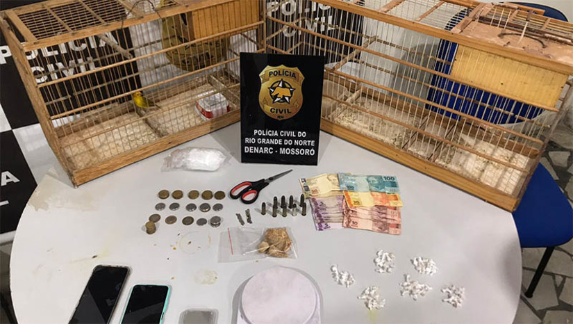 Imagem 1 - Idoso de 62 anos é preso por tráfico de drogas no Forno Velho, em Mossoró. As diligências ocorreram nesta segunda-feira (16), após uma denúncia sobre um possível ponto de drogas no município. Ao chegar no local, foi encontrada na posse do suspeito e posteriormente apreendida uma vasta quantidade de drogas fracionadas, além de entorpecentes que ainda seriam separados, duas balanças de precisão e dinheiro fracionado, o que configura crime de tráfico de drogas. Na delegacia, o homem assumiu que os entorpecentes eram de sua propriedade e que ele mesmo era responsável por fazer a comercialização. Imagem 1 - Idoso de 62 anos é preso por tráfico de drogas no Forno Velho, em Mossoró. As diligências ocorreram nesta segunda-feira (16), após uma denúncia sobre um possível ponto de drogas no município. Ao chegar no local, foi encontrada na posse do suspeito e posteriormente apreendida uma vasta quantidade de drogas fracionadas, além de entorpecentes que ainda seriam separados, duas balanças de precisão e dinheiro fracionado, o que configura crime de tráfico de drogas. Na delegacia, o homem assumiu que os entorpecentes eram de sua propriedade e que ele mesmo era responsável por fazer a comercialização.