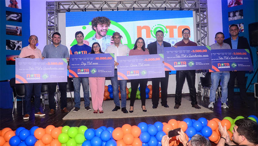 Imagem 1 - PMM vai pagar R$ 25 mil em prêmios no quarto sorteio do ano do programa “Nota Mossoró”. O sorteio será realizado no próximo dia 29 de novembro. Para participar do programa, os cidadãos devem efetuar compras no comércio e cadastrar o CPF na nota fiscal. Após isso, deve cadastrar-se no site do programa e assim acompanhar os sorteios. A cada R$ 30 gastos em serviços, cada participante ganha um cupom. O sorteio acontece a cada dois meses. O primeiro sorteio ocorreu em maio. Já o segundo em julho e o terceiro no último mês de setembro. Cada etapa do programa de incentivo à cidadania fiscal contemplou cinco ganhadores e já distribuiu mais de R$ 75 mil em prêmios em 2023. Imagem 1 - PMM vai pagar R$ 25 mil em prêmios no quarto sorteio do ano do programa “Nota Mossoró”. O sorteio será realizado no próximo dia 29 de novembro. Para participar do programa, os cidadãos devem efetuar compras no comércio e cadastrar o CPF na nota fiscal. Após isso, deve cadastrar-se no site do programa e assim acompanhar os sorteios. A cada R$ 30 gastos em serviços, cada participante ganha um cupom. O sorteio acontece a cada dois meses. O primeiro sorteio ocorreu em maio. Já o segundo em julho e o terceiro no último mês de setembro. Cada etapa do programa de incentivo à cidadania fiscal contemplou cinco ganhadores e já distribuiu mais de R$ 75 mil em prêmios em 2023.