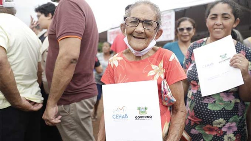 Imagem 1 - Cerca de 159 famílias da Vila Industrial da Alcanorte, em Macau, distante 185 quilômetros da capital do Rio Grande do Norte, receberam nesta sexta-feira (14), os Termos de Cessão de Uso e Posse dos seus imóveis. A ação representa um marco histórico para aproximadamente de 640 pessoas. A iniciativa, que encerra uma luta de mais de quatro décadas, foi possível graças à intervenção do Governo do Estado. Em 2019, foi formado um grupo de trabalho para estudos socioeconômicos e jurídicos da comunidade. Imagem 1 - Cerca de 159 famílias da Vila Industrial da Alcanorte, em Macau, distante 185 quilômetros da capital do Rio Grande do Norte, receberam nesta sexta-feira (14), os Termos de Cessão de Uso e Posse dos seus imóveis. A ação representa um marco histórico para aproximadamente de 640 pessoas. A iniciativa, que encerra uma luta de mais de quatro décadas, foi possível graças à intervenção do Governo do Estado. Em 2019, foi formado um grupo de trabalho para estudos socioeconômicos e jurídicos da comunidade.