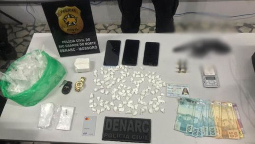 Imagem 1 - Mãe e filho são presos por tráfico de drogas e posse ilegal de arma de fogo em Mossoró. A mulher, de 56 anos, e o filho dela, de 39 anos, foram presos em flagrante, nesta quarta-feira (27), no bairro Santo Antônio, durante uma operação de combate ao tráfico de drogas. Nas casas onde foram cumpridos mandados de busca e apreensão, foram apreendidos um revólver calibre 38 municiado, dinheiro fracionado, balança de precisão e aproximadamente 300 gramas de cocaína. Há 15 dias, os agentes realizaram uma apreensão em uma lanchonete da suspeita que funcionava como fachada para a venda de entorpecentes. Na ocasião, ela conseguiu fugir. Imagem 1 - Mãe e filho são presos por tráfico de drogas e posse ilegal de arma de fogo em Mossoró. A mulher, de 56 anos, e o filho dela, de 39 anos, foram presos em flagrante, nesta quarta-feira (27), no bairro Santo Antônio, durante uma operação de combate ao tráfico de drogas. Nas casas onde foram cumpridos mandados de busca e apreensão, foram apreendidos um revólver calibre 38 municiado, dinheiro fracionado, balança de precisão e aproximadamente 300 gramas de cocaína. Há 15 dias, os agentes realizaram uma apreensão em uma lanchonete da suspeita que funcionava como fachada para a venda de entorpecentes. Na ocasião, ela conseguiu fugir.