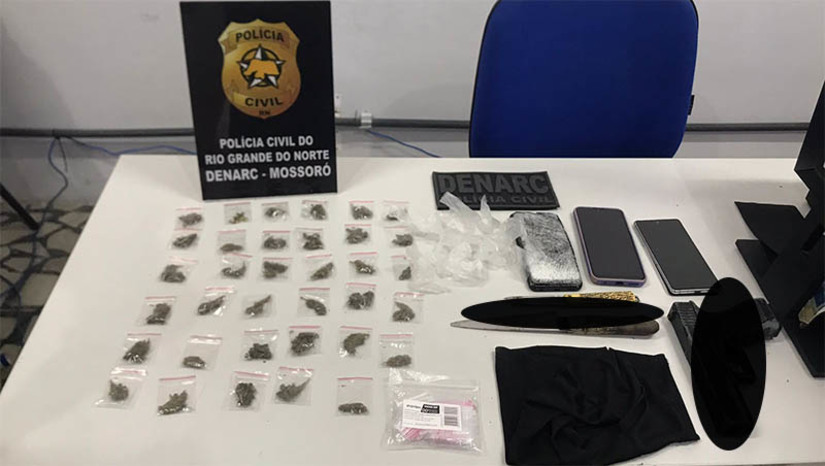 Imagem 1 - Jovem de 19 anos é preso por suspeita de tráfico de drogas no Santo Antônio. A prisão aconteceu no final da manhã desta quinta-feira (2). Daniel Derik Freitas, de 19 anos foi alvo de uma operação conduzida pela Delegacia Especializada em Narcóticos (DENARC/Mossoró). Com ele, os policiais encontraram 34 pacotes de maconha, um simulacro de arma de fogo, uma faca e embalagens para preparo de drogas. Imagem 1 - Jovem de 19 anos é preso por suspeita de tráfico de drogas no Santo Antônio. A prisão aconteceu no final da manhã desta quinta-feira (2). Daniel Derik Freitas, de 19 anos foi alvo de uma operação conduzida pela Delegacia Especializada em Narcóticos (DENARC/Mossoró). Com ele, os policiais encontraram 34 pacotes de maconha, um simulacro de arma de fogo, uma faca e embalagens para preparo de drogas.