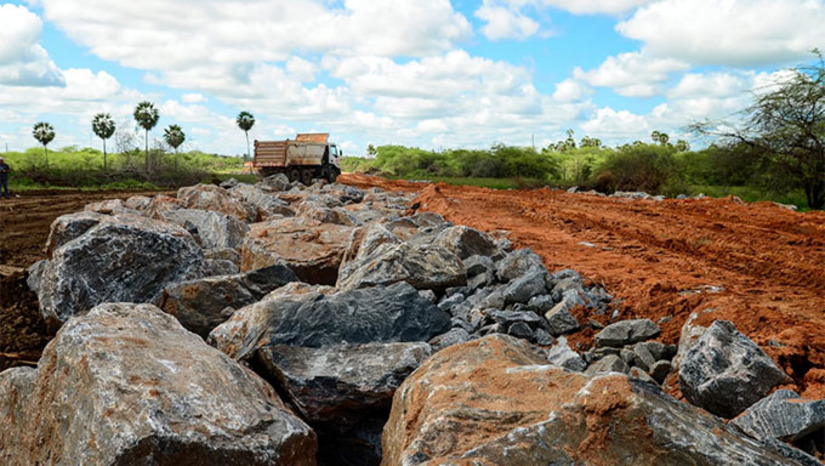 Imagem 1 - A obra está atualmente na fase de troca de solo, que acontece de forma planejada, de acordo com estudos técnicos. Inicialmente é realizada a limpeza de toda a extensão da área, em seguida acontece a retirada do solo mole para colocação da pedra rachão, utilizada como base de pavimentação, terraplenagem e drenagem. Essa fase das obras é essencial para atender à necessidade de compactação do terreno garantindo que a via seja entregue conforme planejada. Que passará a contar com uma circulação mais fluida de veículos na região. A obra representa um marco histórico para a mobilidade urbana da cidade, que irá interligar as BRs 110 e 304. Imagem 1 - A obra está atualmente na fase de troca de solo, que acontece de forma planejada, de acordo com estudos técnicos. Inicialmente é realizada a limpeza de toda a extensão da área, em seguida acontece a retirada do solo mole para colocação da pedra rachão, utilizada como base de pavimentação, terraplenagem e drenagem. Essa fase das obras é essencial para atender à necessidade de compactação do terreno garantindo que a via seja entregue conforme planejada. Que passará a contar com uma circulação mais fluida de veículos na região. A obra representa um marco histórico para a mobilidade urbana da cidade, que irá interligar as BRs 110 e 304.