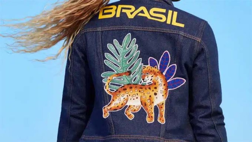 Imagem 1 -  Através de uma parceria com o Instituto Riachuelo, o grupo foi convidado para bordar o principal elemento do traje utilizado no desfile: uma jaqueta jeans com onças, araras e tucanos costurados às costas. Salmira, que é bordadeira há mais de 50 anos, e Jailma, que começou a bordar com uma máquina de costura herdada de sua avó, foram à capital francesa a convite da Embratur e do governo do estado.