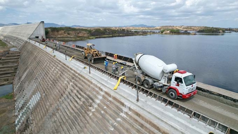 Imagem 1 - Onze anos depois de iniciadas, obras do reservatório caminham para o final. Nesta segunda-feira (29), o secretário de Estado do Meio Ambiente e Recursos Hídricos, Paulo Varella, esteve na barragem inspecionando as obras. O reservatório tem capacidade para acumular 598 milhões de metros cúbicos e foi projetado para garantir segurança hídrica ao Seridó. O vão possui 180 metros de largura e quase 15 metros de altura e garante o abastecimento de água para mais de 300 mil habitantes. O valor total do empreendimento é de mais de R$750 milhões, advindos de verba federal, com contrapartida do Governo do Estado. Imagem 1 - Onze anos depois de iniciadas, obras do reservatório caminham para o final. Nesta segunda-feira (29), o secretário de Estado do Meio Ambiente e Recursos Hídricos, Paulo Varella, esteve na barragem inspecionando as obras. O reservatório tem capacidade para acumular 598 milhões de metros cúbicos e foi projetado para garantir segurança hídrica ao Seridó. O vão possui 180 metros de largura e quase 15 metros de altura e garante o abastecimento de água para mais de 300 mil habitantes. O valor total do empreendimento é de mais de R$750 milhões, advindos de verba federal, com contrapartida do Governo do Estado.