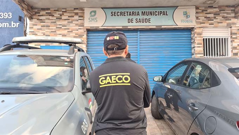 Imagem 1 -  A investigação tem como objetivo de apurar crimes contra a Administração Pública na Prefeitura de Touros e teve início a partir de um inquérito civil que apontou superfaturamento de mais de R$ 700 mil nos valores contratados pela Prefeitura. Entre os crimes investigados na ação estão a apropriação de bens ou rendas públicas, desvio de recursos em proveito próprio ou alheio e enriquecimento ilícito. O MPRN apura indícios de direcionamento na contratação da organização da sociedade civil, superfaturamento nos repasses mensais e desvio de recursos para empresas terceirizadas e agentes públicos. Ao todo, foram cumpridos 24 mandados de busca e apreensão nas cidades de Touros, Natal, Parnamirim, Garanhuns, Caruaru e Quipapá nesta quarta-feira (16).