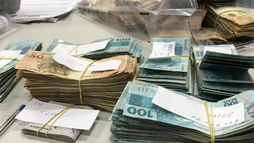 Imagem 1 - Valor encontrado em operação contra desvio de recursos públicos em Touros ultrapassa R$ 530 mil. Segundo MPRN, após a abertura de malotes e recontagem das cédulas apreendidas na operação 3° Batimento, deflagrada na última quarta-feira (16), o valor total em dinheiro vivo encontrado subiu para R$ 531.413. Essa quantia expressiva em espécie reforça as suspeitas de desvio de recursos do município de Touros. O esquema envolveria uma organização da sociedade civil que atuava na área da saúde do município, com irregularidades como superfaturamento de contratos e despesas fictícias. Imagem 1 - Valor encontrado em operação contra desvio de recursos públicos em Touros ultrapassa R$ 530 mil. Segundo MPRN, após a abertura de malotes e recontagem das cédulas apreendidas na operação 3° Batimento, deflagrada na última quarta-feira (16), o valor total em dinheiro vivo encontrado subiu para R$ 531.413. Essa quantia expressiva em espécie reforça as suspeitas de desvio de recursos do município de Touros. O esquema envolveria uma organização da sociedade civil que atuava na área da saúde do município, com irregularidades como superfaturamento de contratos e despesas fictícias.