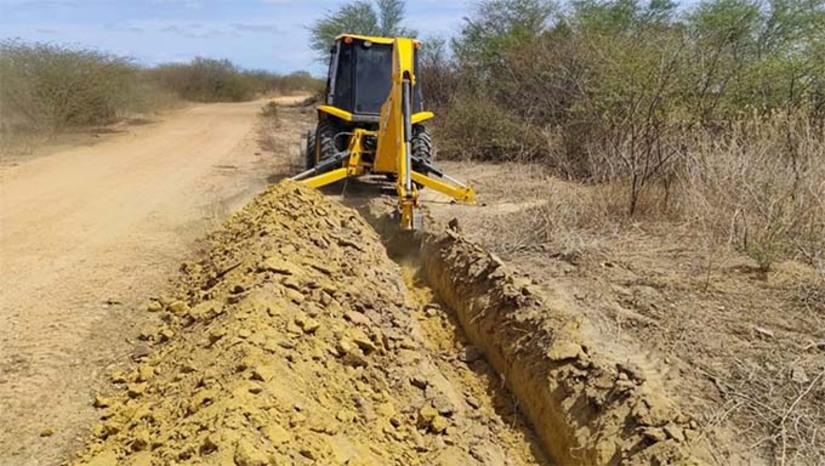 Imagem 1 - Conforme o cronograma, o serviçode colocação da adutora já passou pelas comunidades de Melancias e Carmo e segue para Sussuarana. Ontem (9), os primeiros trechos foram concluídos, afirma Raniere Barbosa, gerente executivo de desenvolvimento rural da Secretaria de Agricultura. Ao final dos trabalhos, serão 33 quilômetros de adutora e 35 km de distribuição. “O projeto vai contemplar 615 ligações residenciais com 33 quilômetros de adutora para beneficiar todas essas comunidades”, explicou Raniere. Imagem 1 - Conforme o cronograma, o serviçode colocação da adutora já passou pelas comunidades de Melancias e Carmo e segue para Sussuarana. Ontem (9), os primeiros trechos foram concluídos, afirma Raniere Barbosa, gerente executivo de desenvolvimento rural da Secretaria de Agricultura. Ao final dos trabalhos, serão 33 quilômetros de adutora e 35 km de distribuição. “O projeto vai contemplar 615 ligações residenciais com 33 quilômetros de adutora para beneficiar todas essas comunidades”, explicou Raniere.