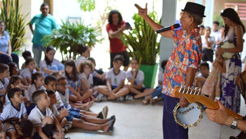 Imagem 1 -  Estudantes das escolas municipais Rotary Mossoró e Monsenhor Mota, encerraram as atividades escolares nesta quarta-feira (11), com a apresentação do projeto “Coco na Escola”, liderado pelo Mestre Concriz do Coco. Um dos principais representantes do coco nordestino, no RN, Mestre Concriz apresentou aos estudantes a riqueza cultura da embolada, do coco de improviso e da literatura de cordel, com uma apresentação musical que conta com pandeiro, ganzá, zabumba e guitarra. “É uma alegria poder ver essa meninada cantando coco com a gente, aprendendo a improvisar, e mostrando que a cultura pode sobreviver com a juventude”, comentou o artista. O projeto encerra a série de três apresentações na tarde desta quarta-feira (11), às 16h30, na Unidade de Educação Infantil Mário Negócio, na Baixinha.