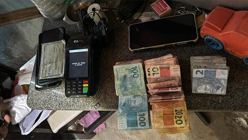 Imagem 1 - Denarc desarticula pontos de tráfico e prende quatro suspeitos no Pirrichil . A ação aconteceu na segunda-feira (30), mas só foi divulgada nesta quinta (2). De acordo com as investigações, uma facção criminosa havia estruturado um sistema organizado de tráfico de drogas, funcionando de forma similar a um estabelecimento comercial. Diversas "pontos de drogas" operavam em uma mesma rua, incluindo um ponto específico destinado ao controle financeiro, conhecido como "caixa". Além dos quatro presos, os policiais também apreenderam uma pistola calibre .40, três carregadores, 27 munições, drogas, balanças de precisão, embalagens, cerca de R$ 15 mil em espécie, uma máquina de cartão de crédito e outros itens relacionados ao tráfico. Imagem 1 - Denarc desarticula pontos de tráfico e prende quatro suspeitos no Pirrichil . A ação aconteceu na segunda-feira (30), mas só foi divulgada nesta quinta (2). De acordo com as investigações, uma facção criminosa havia estruturado um sistema organizado de tráfico de drogas, funcionando de forma similar a um estabelecimento comercial. Diversas "pontos de drogas" operavam em uma mesma rua, incluindo um ponto específico destinado ao controle financeiro, conhecido como "caixa". Além dos quatro presos, os policiais também apreenderam uma pistola calibre .40, três carregadores, 27 munições, drogas, balanças de precisão, embalagens, cerca de R$ 15 mil em espécie, uma máquina de cartão de crédito e outros itens relacionados ao tráfico.