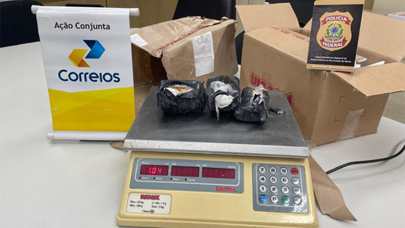 Imagem 1 -  O entorpecente estava acondicionado em duas latas de cereal em pó, envoltas em plástico e fita adesiva preta, dentro de uma caixa de papelão.  As investigações iniciais indicam que a encomenda foi postada na cidade de Guarulhos/SP e tinha como destino final o município de Pau dos Ferros/RN, no interior do estado.  A ação integra o conjunto de operações permanentes da Polícia Federal voltadas ao combate do tráfico de drogas por meio do sistema de encomendas postais.