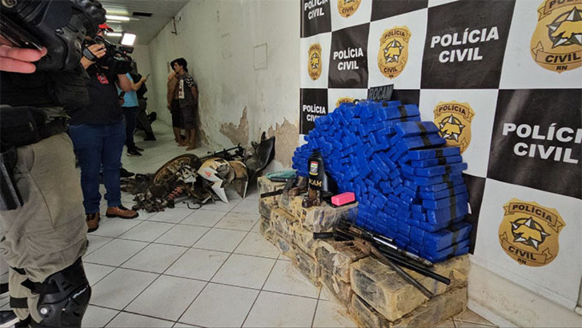   A Polícia Militar havia sido chamada para conter um homem visto armado. No local, os policiais desconfiaram do irmão do suspeito e descobriram que ele estava escondendo cerca de 270 quilos de maconha no quintal de casa. Revistaram o local e encontraram armas de fabricação caseira, uma moto desmanchada, possivelmente roubada, celulares e a droga.