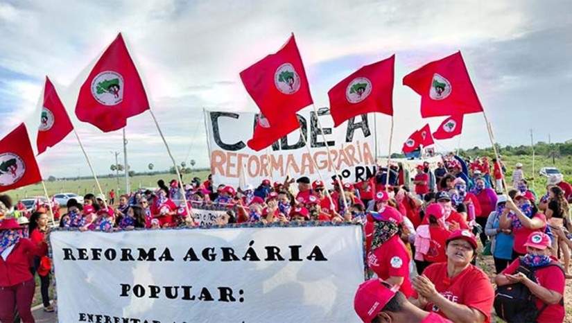 Imagem 1 - A ação faz parte da Jornada Nacional de Lutas das Mulheres Sem Terra, relacionada ao Dia Internacional da Mulher. O movimento reivindica medidas contra o feminicídio, a implementação da reforma agrária e a regularização de famílias na Chapada do Apodi, entre Apodi e Felipe Guerra. O MST exige a presença de representantes do Incra e do DNOCS. Segundo a PRF, a rodovia foi bloqueada nos dois sentidos por volta das 6h, e equipes de segurança foram acionadas para acompanhar a situação. Imagem 1 - A ação faz parte da Jornada Nacional de Lutas das Mulheres Sem Terra, relacionada ao Dia Internacional da Mulher. O movimento reivindica medidas contra o feminicídio, a implementação da reforma agrária e a regularização de famílias na Chapada do Apodi, entre Apodi e Felipe Guerra. O MST exige a presença de representantes do Incra e do DNOCS. Segundo a PRF, a rodovia foi bloqueada nos dois sentidos por volta das 6h, e equipes de segurança foram acionadas para acompanhar a situação.