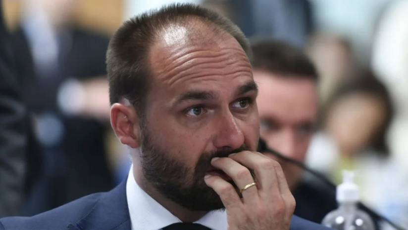   A Primeira Turma do STF condenou por unanimidade o ex-deputado Eduardo Bolsonaro a 4 anos e dois meses de prisão e oito anos de inelegibilidade por coação no curso do processo, ao concluir que ele articulou sanções dos EUA contra o Brasil para tentar blindar o pai, Jair Bolsonaro. A defesa alegou que houve apenas interlocução política sem poder de decisão, mas o relator Alexandre de Moraes ressaltou os prejuízos causados ao país por desinformação. Morando nos EUA, onde perdeu o mandato por faltas, ele dificilmente cumprirá a pena.